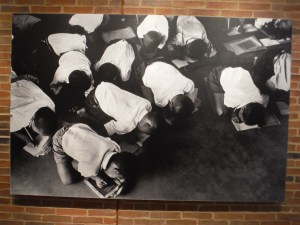 Children trying to do their lessons on the floor in a crowded school.